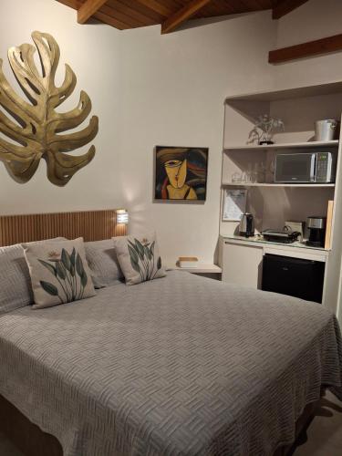 a bedroom with a bed and a kitchen at Suíte Vista Mar Praia Estaleiro Balneário Camboriú in Balneário Camboriú
