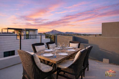 a table and chairs on a balcony with a sunset at Scottsdale 3BR with Private XL Rooftop, 2Car Garage, Heated Pool & Hot Tub, EV L2, 12min to Airport in Scottsdale
