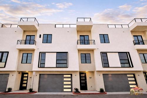 a large white building with four garage doors at Scottsdale 3BR with Private XL Rooftop, 2Car Garage, Heated Pool & Hot Tub, EV L2, 12min to Airport in Scottsdale