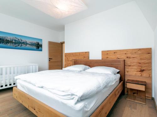 a bedroom with a large bed with a wooden headboard at Panorama Loft in Wörgl