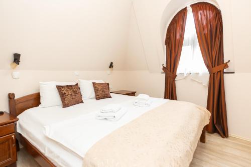 a bedroom with a white bed with a window at DOWNTOWN ROOMS in Niš
