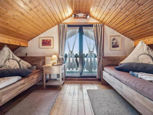 a bedroom with two beds and a large window at Das Haus am Wald in Waltershausen