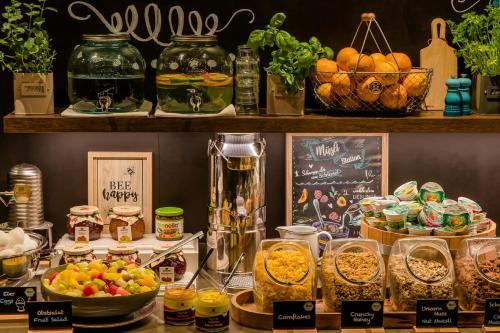 a counter with many different types of food on it at Motel One München-Campus in Munich