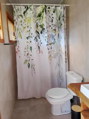 a bathroom with a shower curtain with a toilet at Morada da Mata in Candelária
