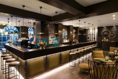 a bar in a restaurant with stools and tables at Motel One Newcastle in Newcastle upon Tyne