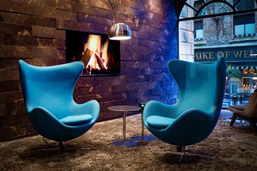 two blue chairs in front of a fireplace at Motel One Newcastle in Newcastle upon Tyne