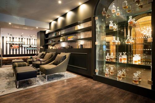 a bar with couches and chairs in a room at Motel One Newcastle in Newcastle upon Tyne
