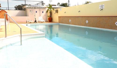 a swimming pool with blue water in front of a building at Santorini Twin Waters in Mudjimba