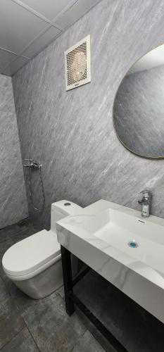 a bathroom with a sink and a toilet and a mirror at SAKURA Retreat in Mộc Châu