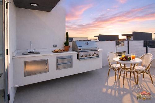 a kitchen with a stove and a table on a balcony at Scottsdale 3BR with Private XL Rooftop, 2Car Garage, Heated Pool & Hot Tub, EV L2, 12min to Airport in Scottsdale