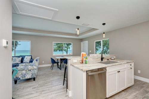 a kitchen with a sink and a living room with a couch at Ami Gulf Lookout-Views Of The Gulf From Every Room-Rooftop Terrace in Bradenton Beach