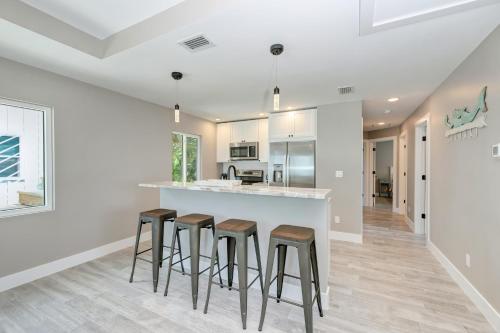 a kitchen with a white counter and stools at Ami Gulf Lookout-Views Of The Gulf From Every Room-Rooftop Terrace in Bradenton Beach