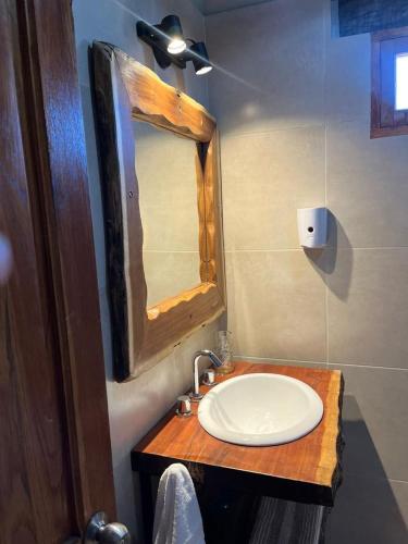 a bathroom with a sink and a mirror at Cabañas El Alemán in Cerrillos