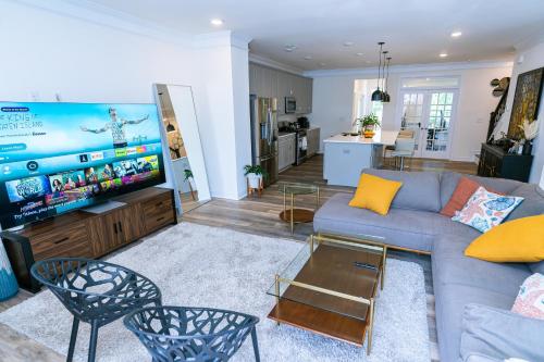 a living room with a couch and a tv at Ensuite King bedroom in Charlotte