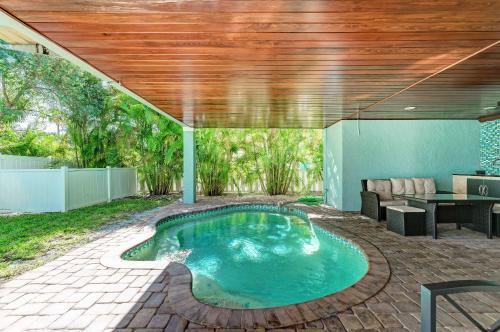 a swimming pool in a backyard with a wooden ceiling at Anna Maria Island Beach Palace in Bradenton Beach