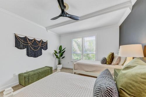 a bedroom with two beds and a ceiling fan at Anna Maria Island Beach Palace in Bradenton Beach