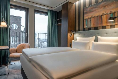 a bedroom with a large white bed and a window at The Cloud One Hamburg-Kontorhaus in Hamburg