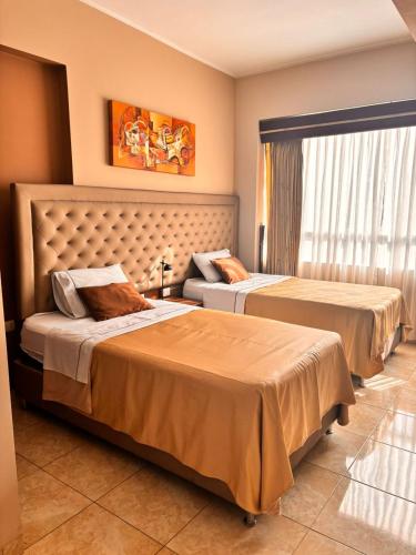 a hotel room with two beds and a window at Gran Hotel Ica in Ica