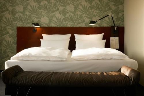 a bed with white pillows and a brown headboard at The Cloud One Gdansk in Gdańsk