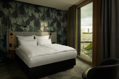 a bedroom with a white bed and a window at The Cloud One Düsseldorf-KöBogen in Düsseldorf