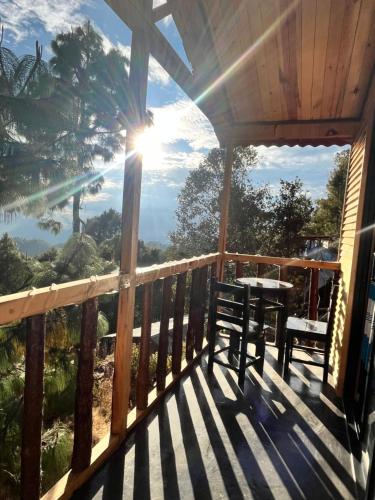 a balcony of a house with a table and chairs at Cabaña OLIN in San Mateo Río Hondo