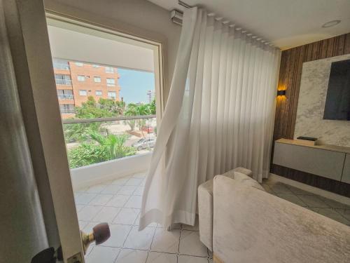 a bedroom with a large window with a view of a building at Margarita 93 in Barranquilla