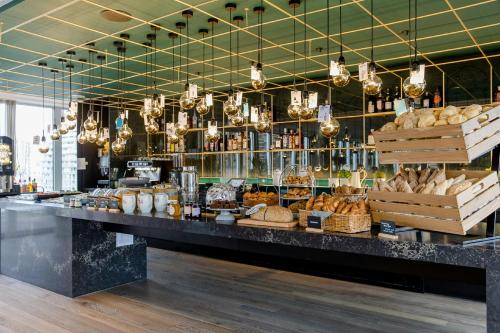 a bakery with a counter with lots of bread at Motel One Rotterdam in Rotterdam