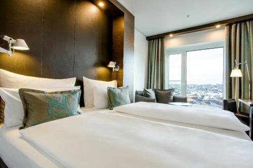 a hotel room with two beds and a window at Motel One Wien-Hauptbahnhof in Vienna