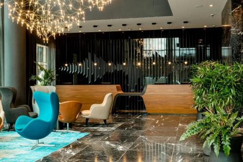 a lobby with a table and chairs and lights at Motel One Köln-Messe in Cologne