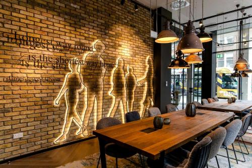 a dining room with a brick wall and a table at Motel One Dublin in Dublin