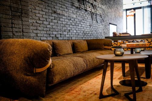 a living room with a couch and a brick wall at Motel One Dublin in Dublin