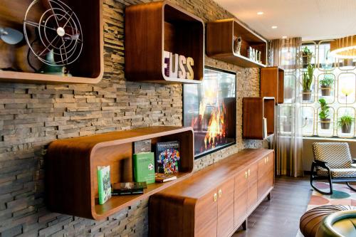 a living room with a tv on a brick wall at Motel One Essen in Essen