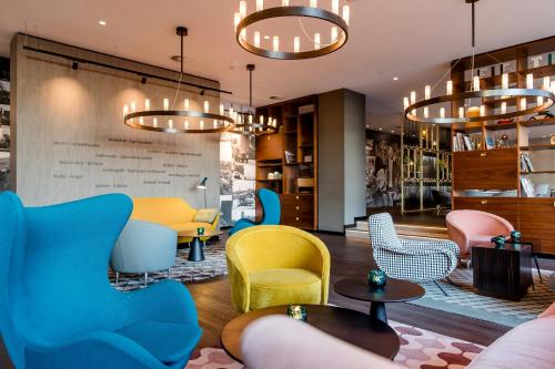 a lobby with colorful chairs and tables at Motel One Essen in Essen