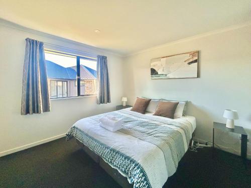 a bedroom with a bed and a large window at Star River in Lake Tekapo