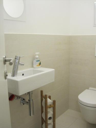 a bathroom with a white sink and a toilet at Apartment with parking on premise in Vienna