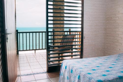 a room with a balcony with a view of the ocean at Casa triplex Lagoinha in Lagoinha