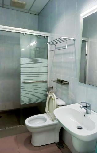 a bathroom with a white toilet and a sink at New Palace Inn in Miri