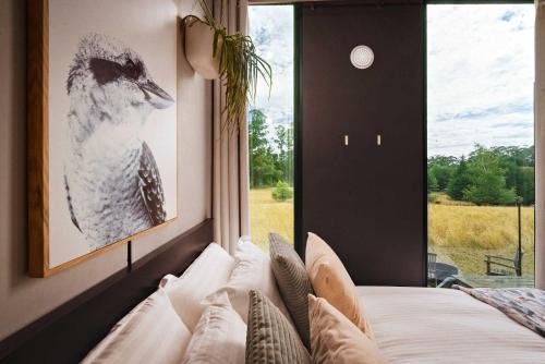 a bedroom with a bird picture on a window at The Ridge by Tiny Away in Korweinguboora