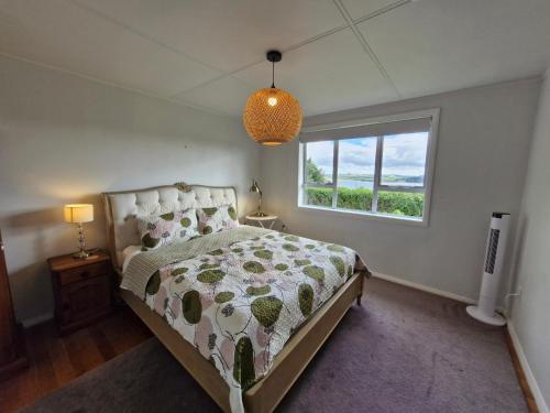 a bedroom with a bed and a window at Country Harbourside Escape in Whakapirau