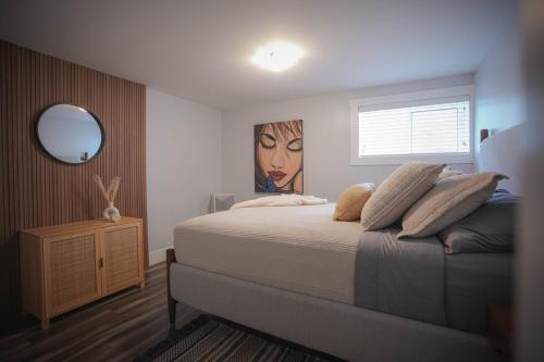 a bedroom with a bed with a painting of a woman at Warm and Welcoming Basement in Dieppe