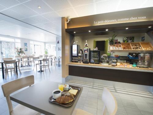 a table with a tray of food on it in a restaurant at B&B HOTEL Tours Parc Expo St-Avertin in Saint-Avertin