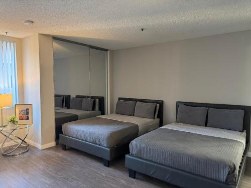 a bedroom with two beds and a mirror at Loft Hollywood apartments FREE Parking and Central Location in Los Angeles