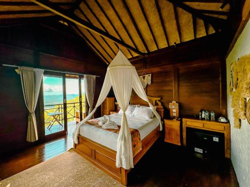 a bedroom with a bed with a mosquito net at Munduk V View House in Munduk