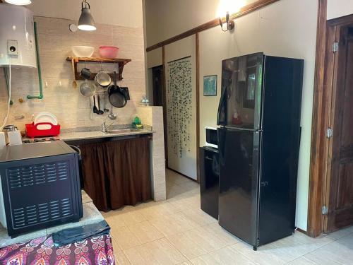 a kitchen with a black refrigerator and a sink at Cabaña - El Bamboo Eventos in Arturo SeguÃ­