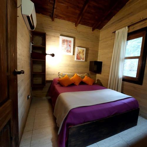 a bedroom with a large bed in a wooden room at Cabaña - El Bamboo Eventos in Arturo SeguÃ­