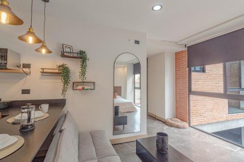 a living room with a couch and a mirror at LOFT en Americana Torre con alberca, Gym, 103 in Guadalajara