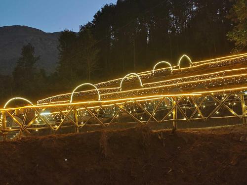 a bunch of lights on a bridge at night at Hilltop camping vanjangi in Pāderu