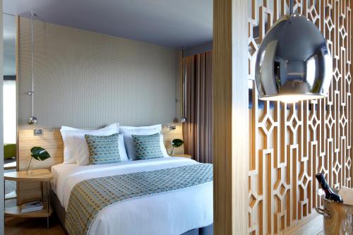 a bedroom with a bed and a mirror on the wall at Wyndham Grand Athens in Athens