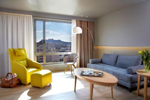 a living room with a blue couch and a yellow chair at Wyndham Grand Athens in Athens