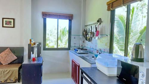 a kitchen with a counter with a sink and a window at Abbas House by Swiss Chalet, 2-room Cottages in Krabi